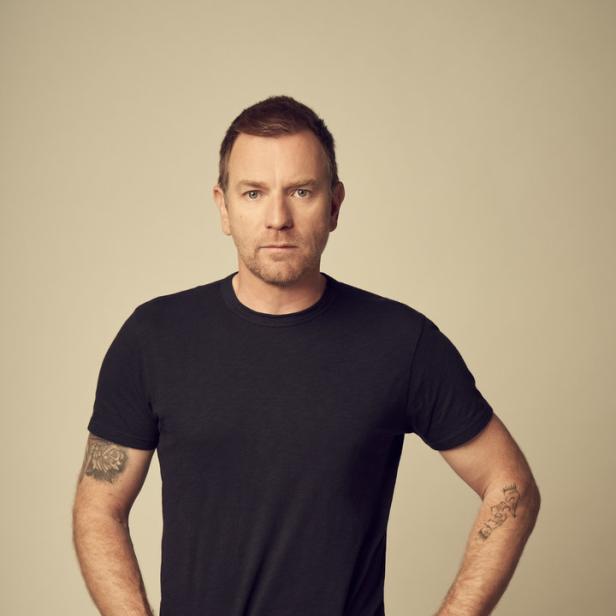 Ewan McGregor posiert mit den Händen in den Hosentaschen.