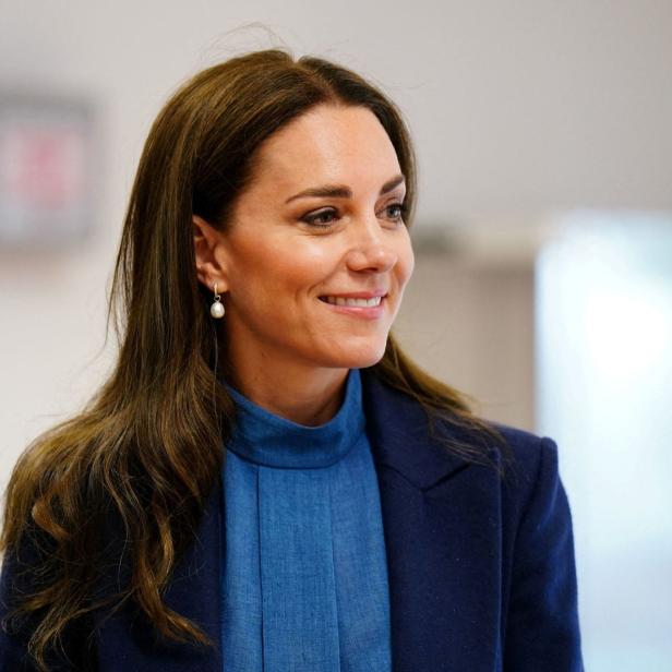 Catherine, Prinzessin von Wales, lächelt in einem blauen Blazer.