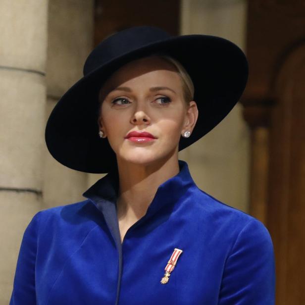 Fürstin Charlène von Monaco mit Hut und blauem Blazer mit Orden.