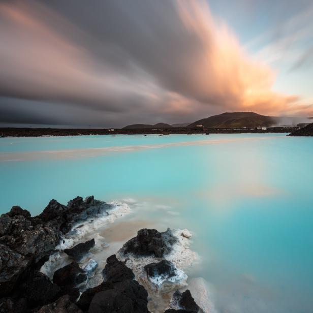 Die Blaue Lagune in Island mit milchig-blauem Wasser und dunklem Lavagestein.