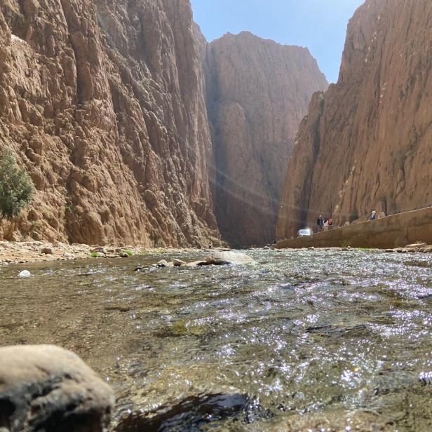 Die Todra-Schlucht in Marokko mit einem Fluss im Vordergrund.