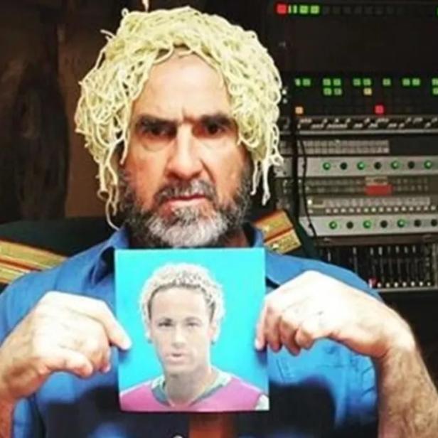 Ein Mann mit Spaghetti auf dem Kopf hält ein Bild von Neymar in den Händen.