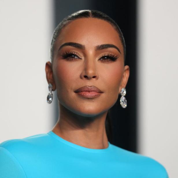 Porträt von Kim Kardashian mit blauem Oberteil und auffälligen Ohrringen.
