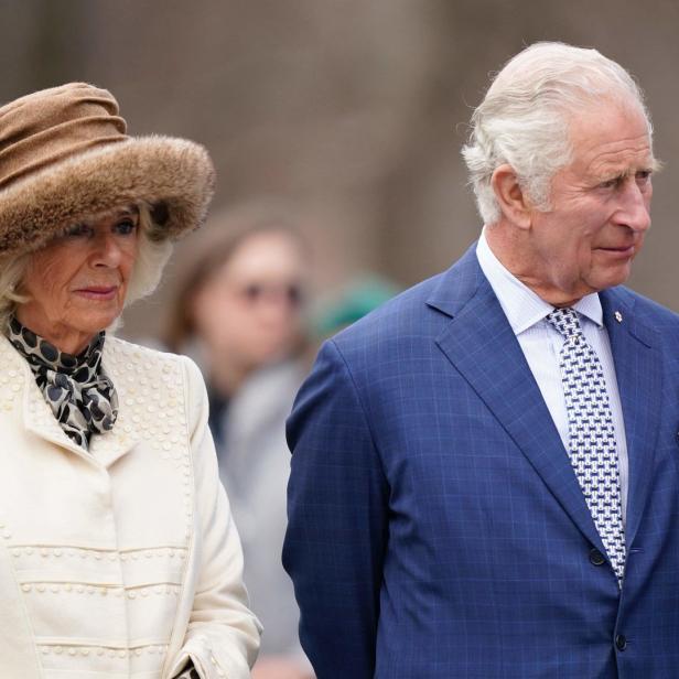 König Charles und Königin Camilla bei einer Veranstaltung im Freien.