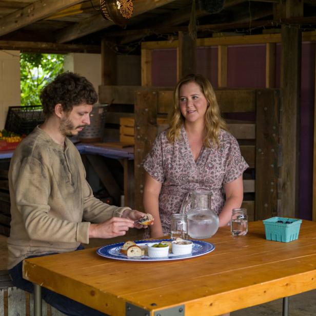 Amy Schumer und ihr Mann Chris Fischer sitzen an einem Tisch mit Snacks.