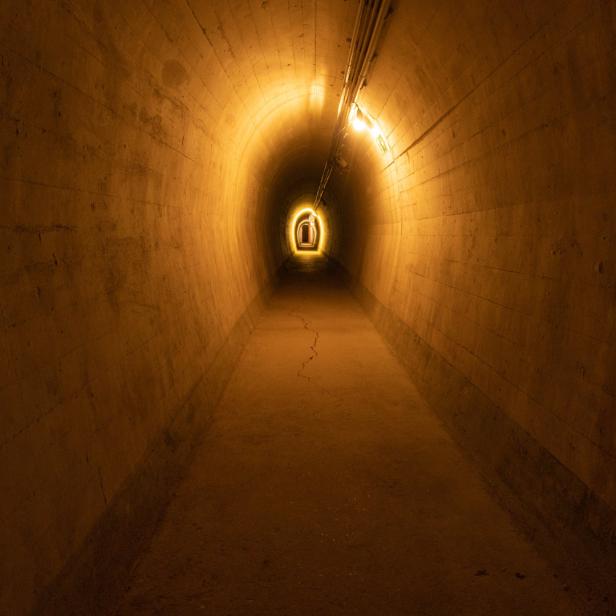 Ein langer, beleuchteter Tunnel mit Betonwänden.