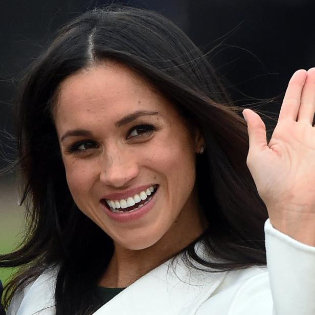Meghan Markle lächelt und winkt in die Kamera.