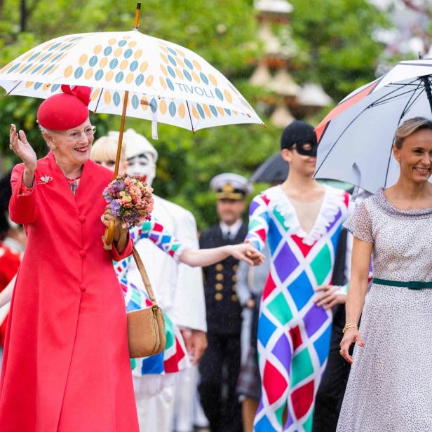 Königin Margrethe II. und Kronprinzessin Mary von Dänemark im Tivoli bei Regen.