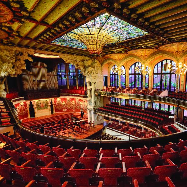 Der Palau de la Música Catalana in Barcelona mit rotem Gestühl und einem Buntglasfenster in der Decke.