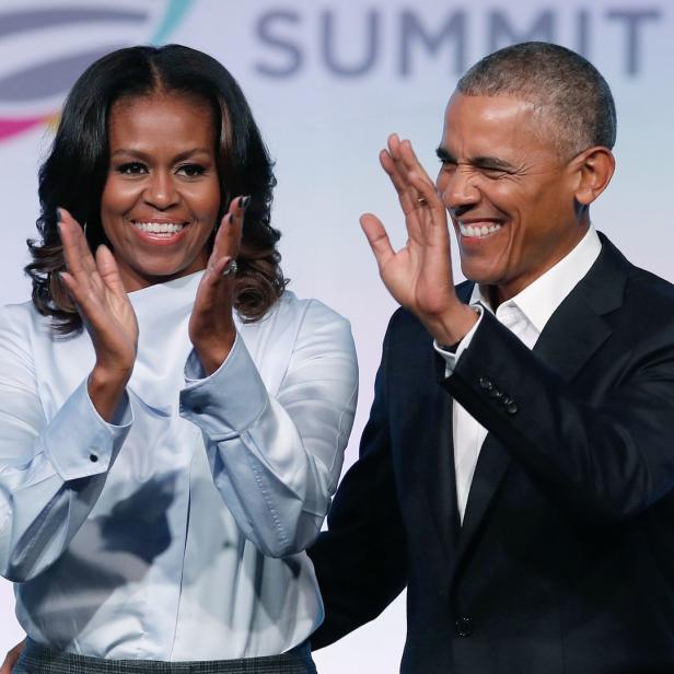 Michelle und Barack Obama klatschen bei einer Veranstaltung.