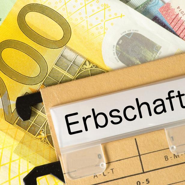 Mehrere Euro-Geldscheine liegen unter einem Ordner mit der Aufschrift „Erbschaft“.