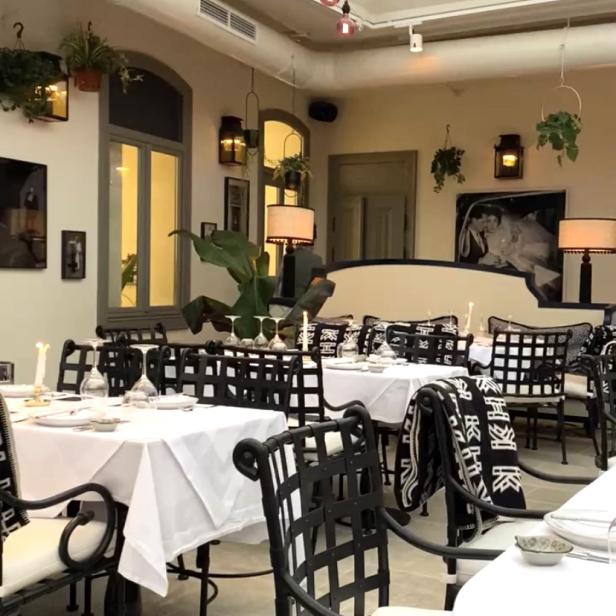 Ein elegant gedeckter Tisch in einem hellen Restaurant mit Glasdach.