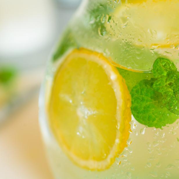 Ein Krug mit erfrischendem Zitronen- und Minzwasser, bedeckt mit Wassertropfen.
