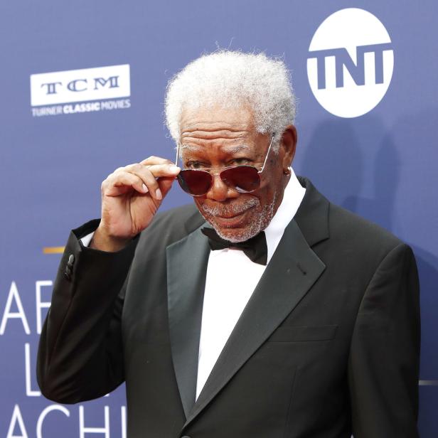 Morgan Freeman posiert auf dem roten Teppich mit Sonnenbrille und Smoking.