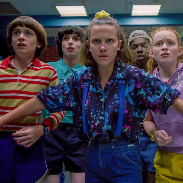 Die jungen Darsteller der Serie „Stranger Things“ blicken besorgt in die Ferne.