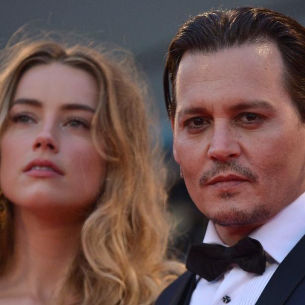 Johnny Depp und Amber Heard posieren auf einem roten Teppich.