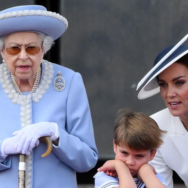 Königin Elisabeth II., Prinz Louis und Prinzessin Kate auf einem Balkon.