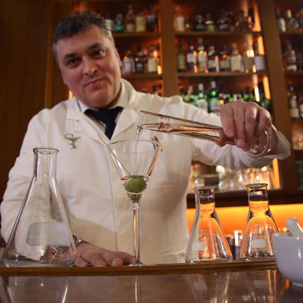 Heinz Kaiser mixt einen Drink mit Messzylinder und Laborgläsern.