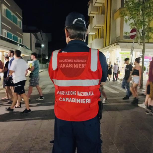 Ein Mitglied der Associazione Nazionale Carabinieri steht auf einer belebten Straße.