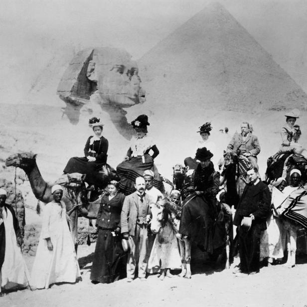 Eine Reisegruppe posiert vor der Sphinx und einer Pyramide in Ägypten.