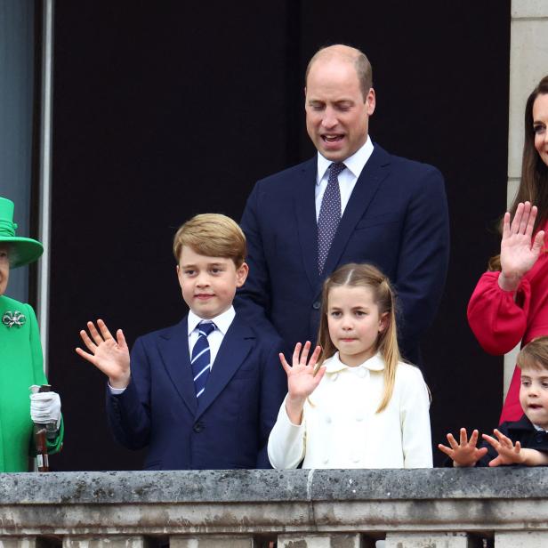 Königin Elisabeth II. mit Prinz William, Kate und ihren Kindern auf einem Balkon, die dem Publikum zuwinken.