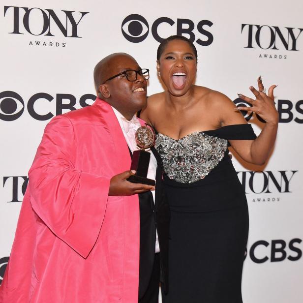 Jennifer Hudson und ein Mann mit einem Tony Award posieren vor einer Wand mit Tony Awards-Logos.