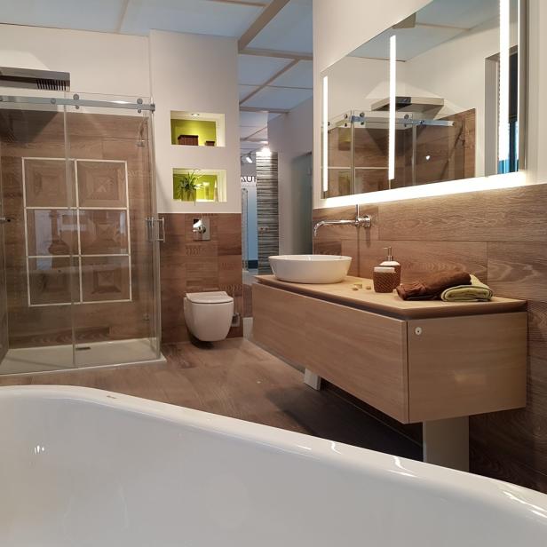 Ein modernes Badezimmer mit Dusche, Toilette und Waschtisch in Holztönen.