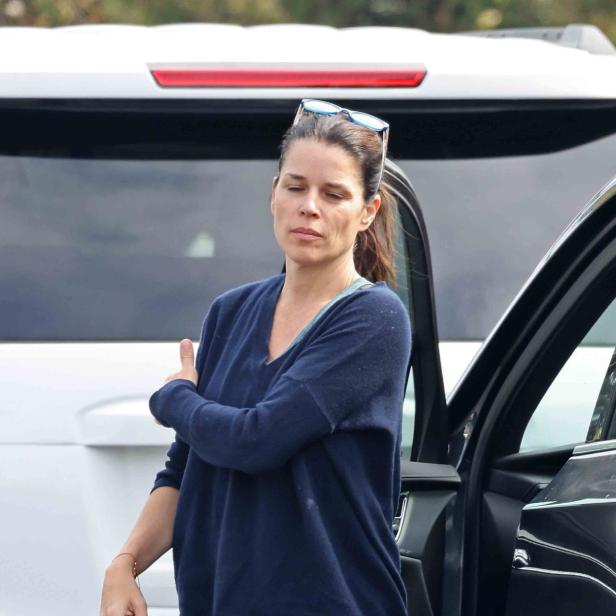 Neve Campbell steigt aus einem Auto.