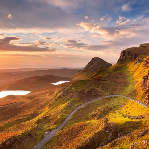 Eine Straße schlängelt sich durch die hügelige Landschaft von Quiraing auf der Isle of Skye.