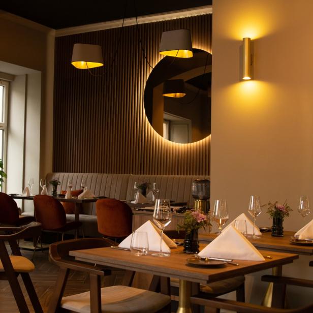 Ein elegant eingerichtetes Restaurant mit gedeckten Tischen und gedämpfter Beleuchtung.