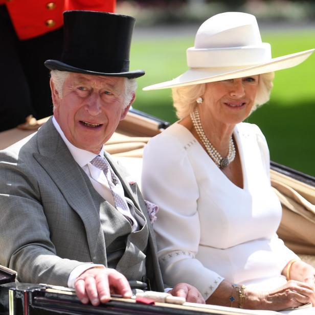 König Charles III. und Königin Camilla fahren in einer Kutsche.