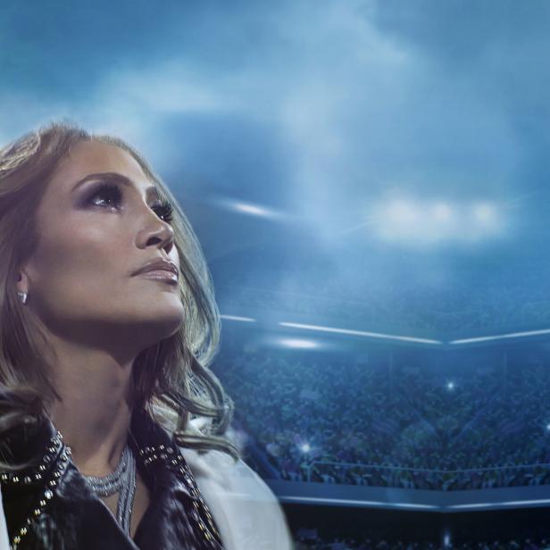 Jennifer Lopez blickt in einem Stadion voller Menschen nach oben.