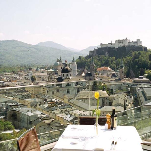 Blick von einer Terrasse auf Salzburg mit der Festung Hohensalzburg im Hintergrund.