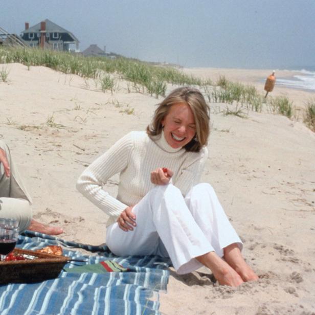 Jack Nicholson und Diane Keaton sitzen lachend am Strand bei einem Picknick.