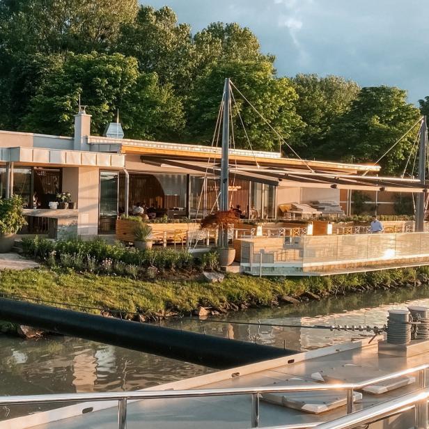 Ein modernes Restaurant befindet sich am Ufer eines Flusses.