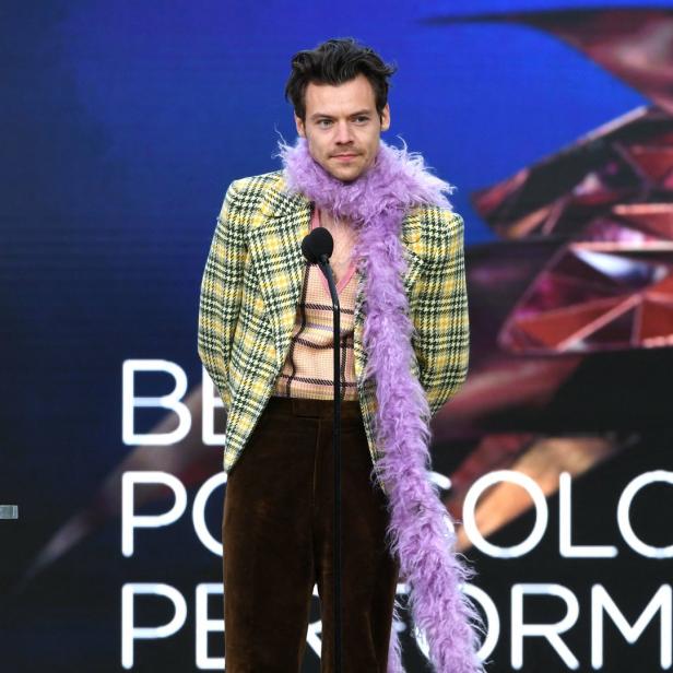 Harry Styles mit einer lila Federboa bei einer Preisverleihung.