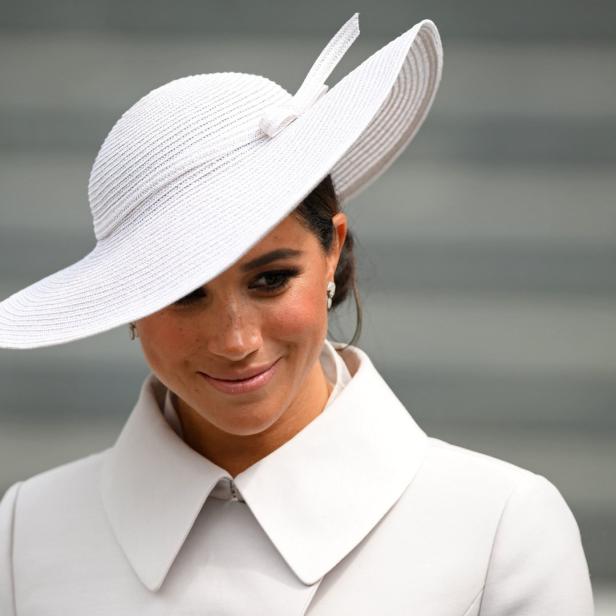 Meghan, Herzogin von Sussex, trägt einen weißen Hut und einen passenden Mantel.