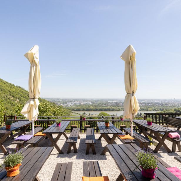 Ein Restaurant mit Tischen und Bänken bietet einen Panoramablick auf die Stadt.