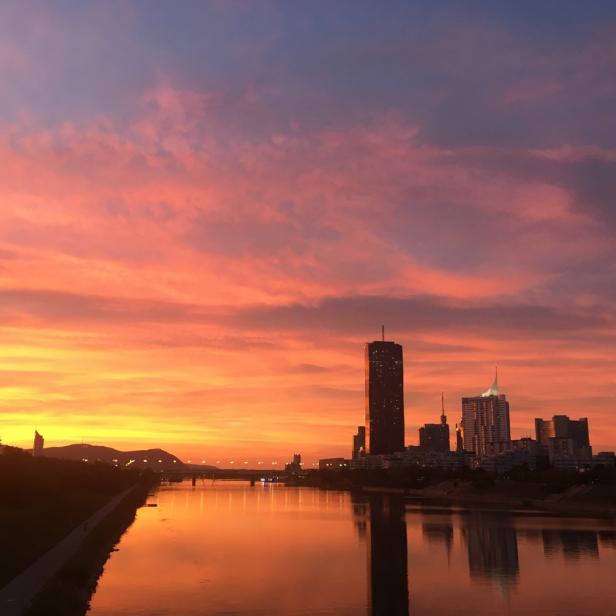 Sonnenuntergang über der Donau in Wien mit Blick auf die Skyline.
