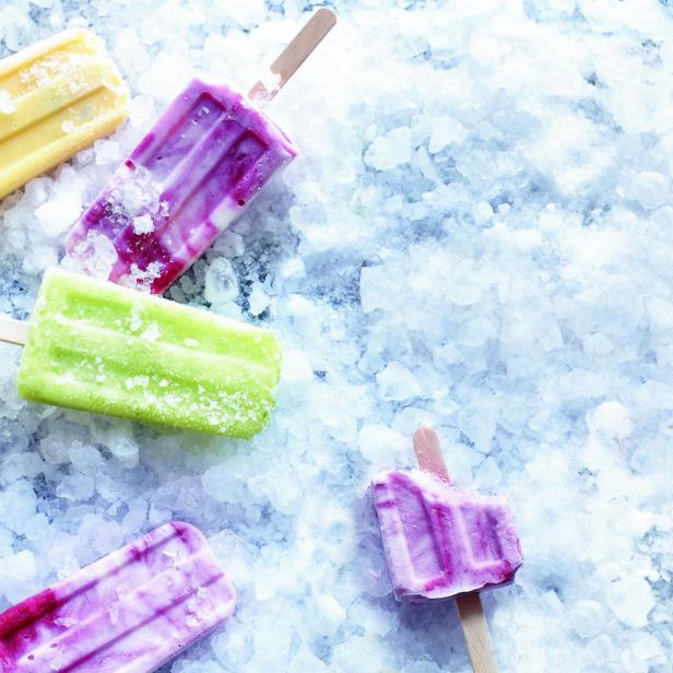Mehrfarbige Eis am Stiel liegen auf zerstoßenem Eis.