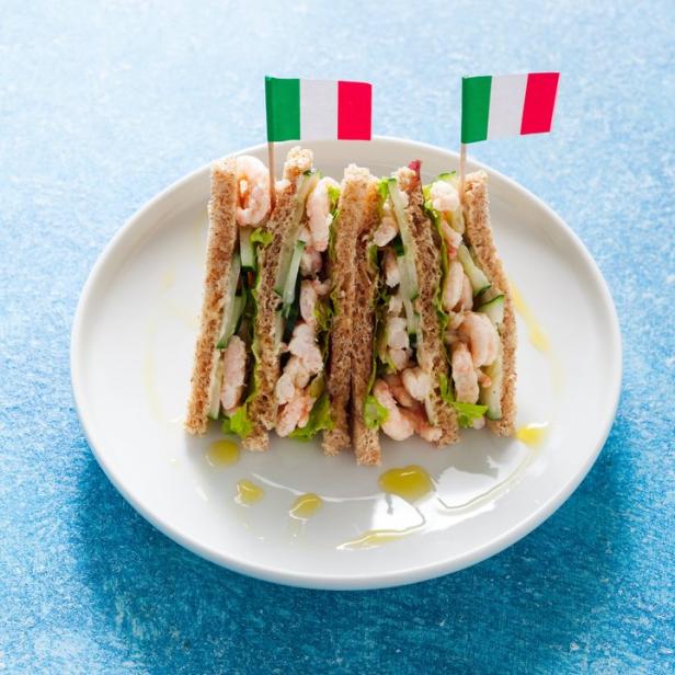 Ein Krabbensandwich mit Salat und Gurke, dekoriert mit italienischen Flaggen.