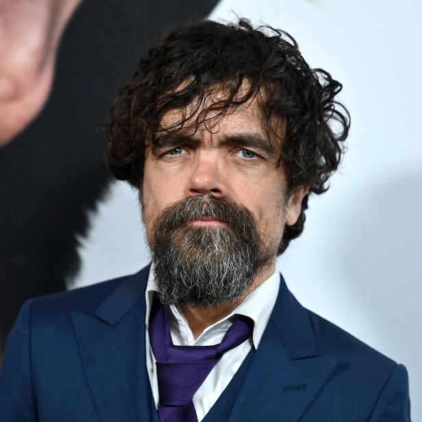 Porträt von Peter Dinklage mit Bart und dunklem Anzug.