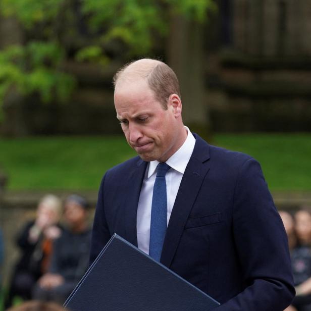 Prinz William hält eine blaue Mappe in seinen Händen.