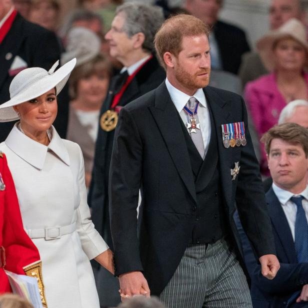 Prinz Harry und Meghan Markle halten Händchen bei einer Veranstaltung.