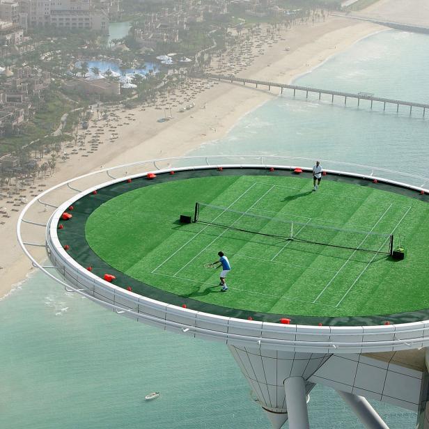 Zwei Personen spielen Tennis auf dem Dach des Burj Al Arab in Dubai.
