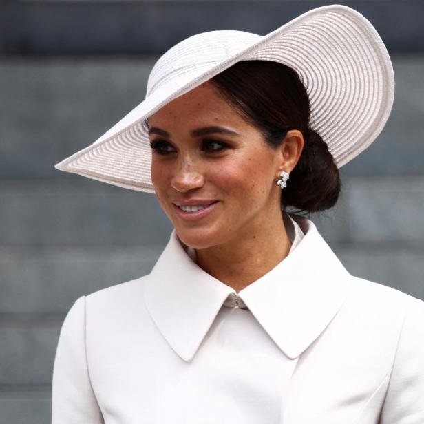 Meghan, Herzogin von Sussex, trägt einen weißen Hut und einen passenden Mantel.