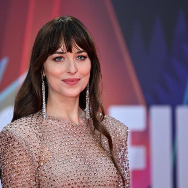 Dakota Johnson auf einem Filmfestival mit einem glitzernden Kleid und langen Ohrringen.