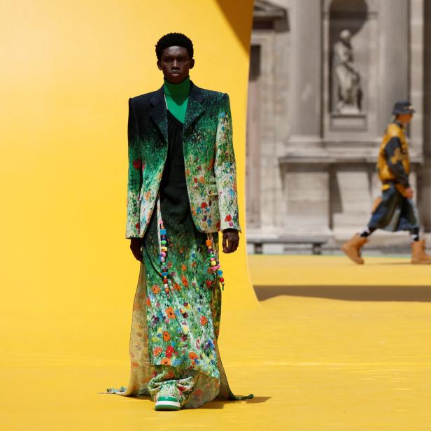 Ein Model in einem floralen Anzug und Rock auf einer Louis Vuitton Modenschau.
