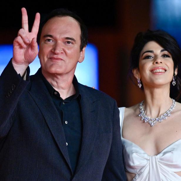 Quentin Tarantino und Daniella Pick posieren auf einem roten Teppich.