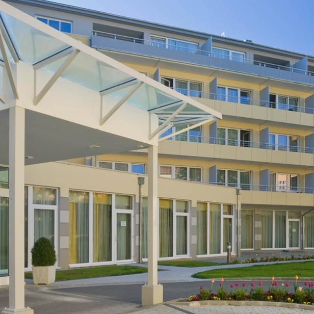 Das Hotel Badener Hof mit seinem Eingangsbereich und einem gepflegten Garten.